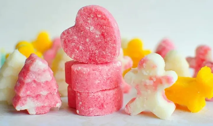 Various shaped colorful sugar scrub pieces, including hearts, trees, and gingerbread figures.